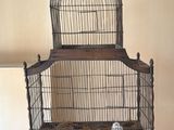 une cage à oiseaux posée sur une table, avec une balle à l'intérieur