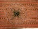 un vieux tapis orné d'un motif, posé sur un sol carrelé