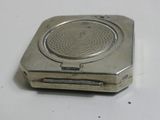 a small silver object on a white surface