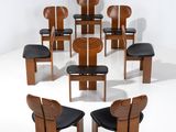 Plusieurs chaises et une table sont disposées en cercle dans une pièce blanche.