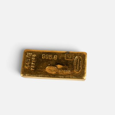 a gold bar on a white surface with a white background