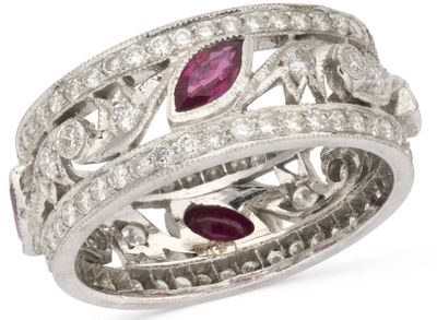 a close up of a diamond and ruby ring on a white background