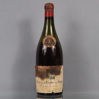 une vieille bouteille de vin posée sur une table en verre