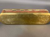 an antique brass cigarette case with a design on the front