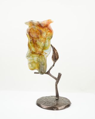a close up of a statue of an owl on a branch