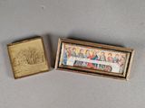 une petite boîte ornée d'une peinture, à côté d'une autre petite boîte ornée d'une peinture
