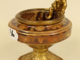 a small statue of a boy sitting in a bowl