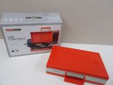 une boîte rouge contenant un lecteur CD, posée sur une table