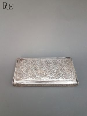 un étui à cigarettes ancien en argent, orné d'un motif floral sur le devant