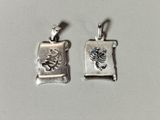 deux breloques en argent ornées d'un scorpion et d'un parchemin