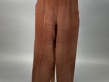 un mannequin vêtu d'un pantalon marron et d'une chemise blanche