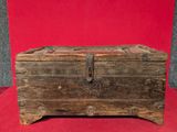 un vieux coffre en bois posé sur un tissu rouge