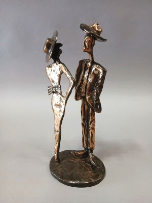 statue of a man and a woman holding hands on a white surface