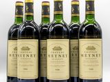 six bottles of wine are lined up on a white surface