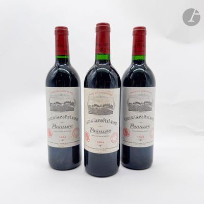 trois bouteilles de vin rouge posées l'une à côté de l'autre sur une surface blanche