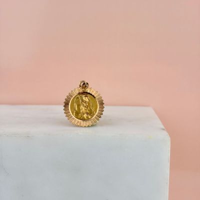 une bague en forme de pièce d'or posée sur un bloc de marbre