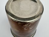 a small metal container with a lid on a white surface