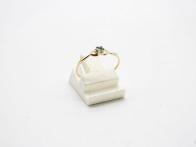 a close up of a gold ring with a green stone on it