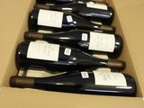 six bouteilles de vin sont posées sur une table dans un carton