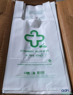 a white bag with a green logo on it sitting in a box