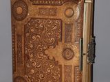 an old book with a decorative design on it sitting on top of a table
