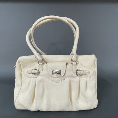 a white purse sitting on top of a black table