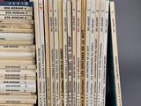a lot of books that are stacked on top of each other