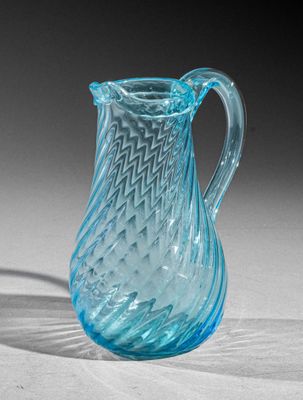 a blue glass pitcher that is sitting on a table
