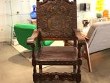 a wooden chair with a leather seat in a room