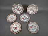 six petites assiettes ornées de motifs floraux, posées sur une table