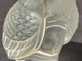 a glass figurine of an owl sitting on a table
