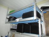 a metal shelf with plates and pans on top of it