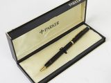 a black pen in a black box on a white surface