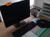 un écran d'ordinateur, un clavier et une souris posés sur un bureau