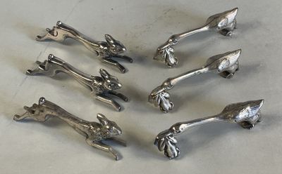 six pieces of silverware sitting on top of a white table