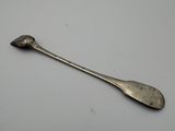 a silver spoon with a long handle sitting on top of a table