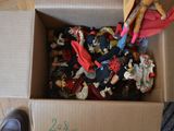 a cardboard box filled with toy figurines and a pair of shoes