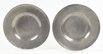 pair of silver plates on stands on a white surface