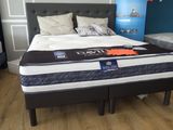 un lit sur lequel est posé un matelas dans une pièce