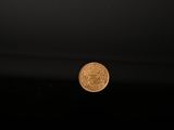 a close up of a gold coin on a black background