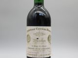 une bouteille de vin rouge avec une étiquette, posée sur une surface blanche