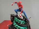 the statue of spider - man is sitting on top of a red box