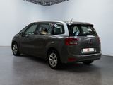 the back of a grey car is parked in a large room