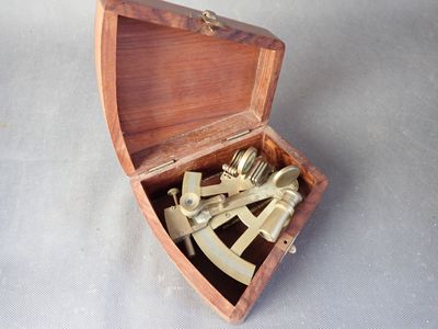 une petite boîte en bois contenant un sexet en laiton