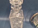 a glass bottle and a clock sitting on a table
