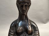 a statue of a woman holding a bowl on her head