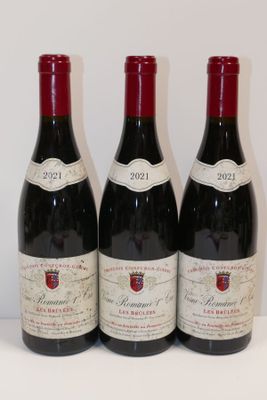 trois bouteilles de vin rouge sont alignées sur une table