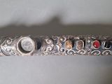 a close up of a silver pen with a lot of beads on it