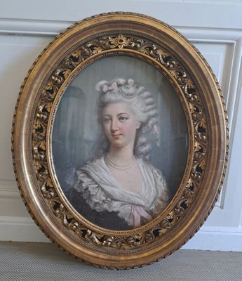 un portrait ancien représentant une femme en robe blanche, dans un cadre doré