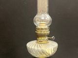 une lampe en verre à l'ancienne avec un pied doré sur fond noir